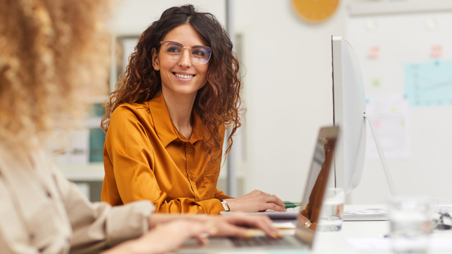 Lady in orange shirt working at computer